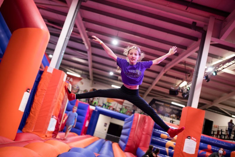 Girl doing a star jump at the Airtastic Inflata Park in Newtownabbey