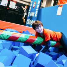 Boy clinging to balance beam